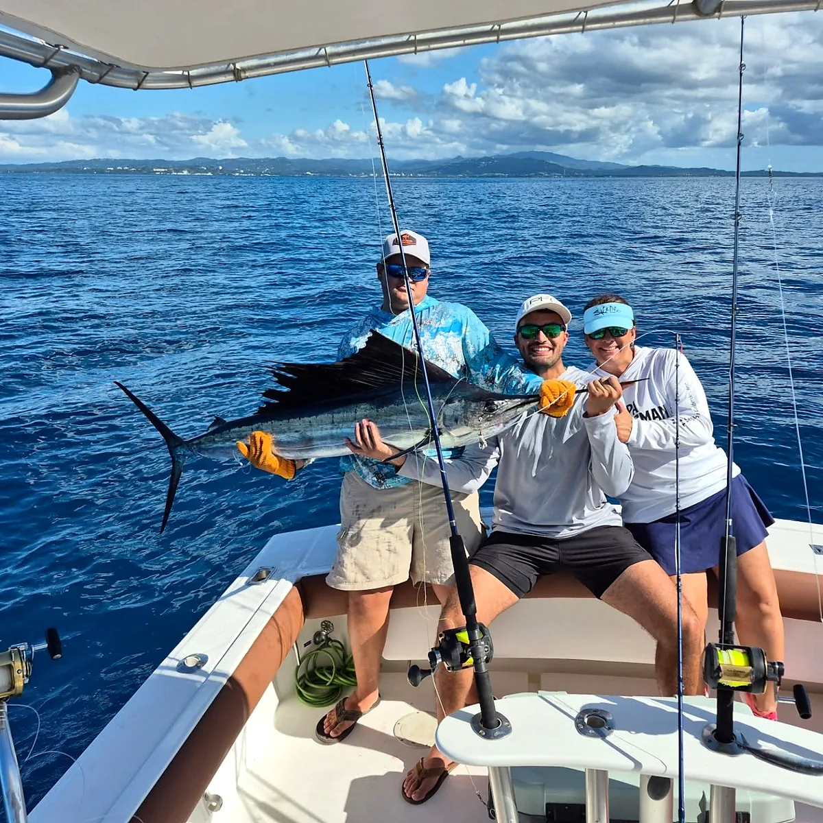 Three charter guests and crew displaying a sailfish off Cabo Rojo.
