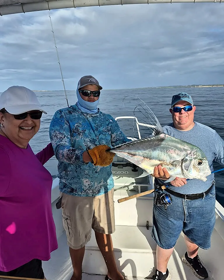 Fishing guests and captain displaying a large catch aboard the boat.