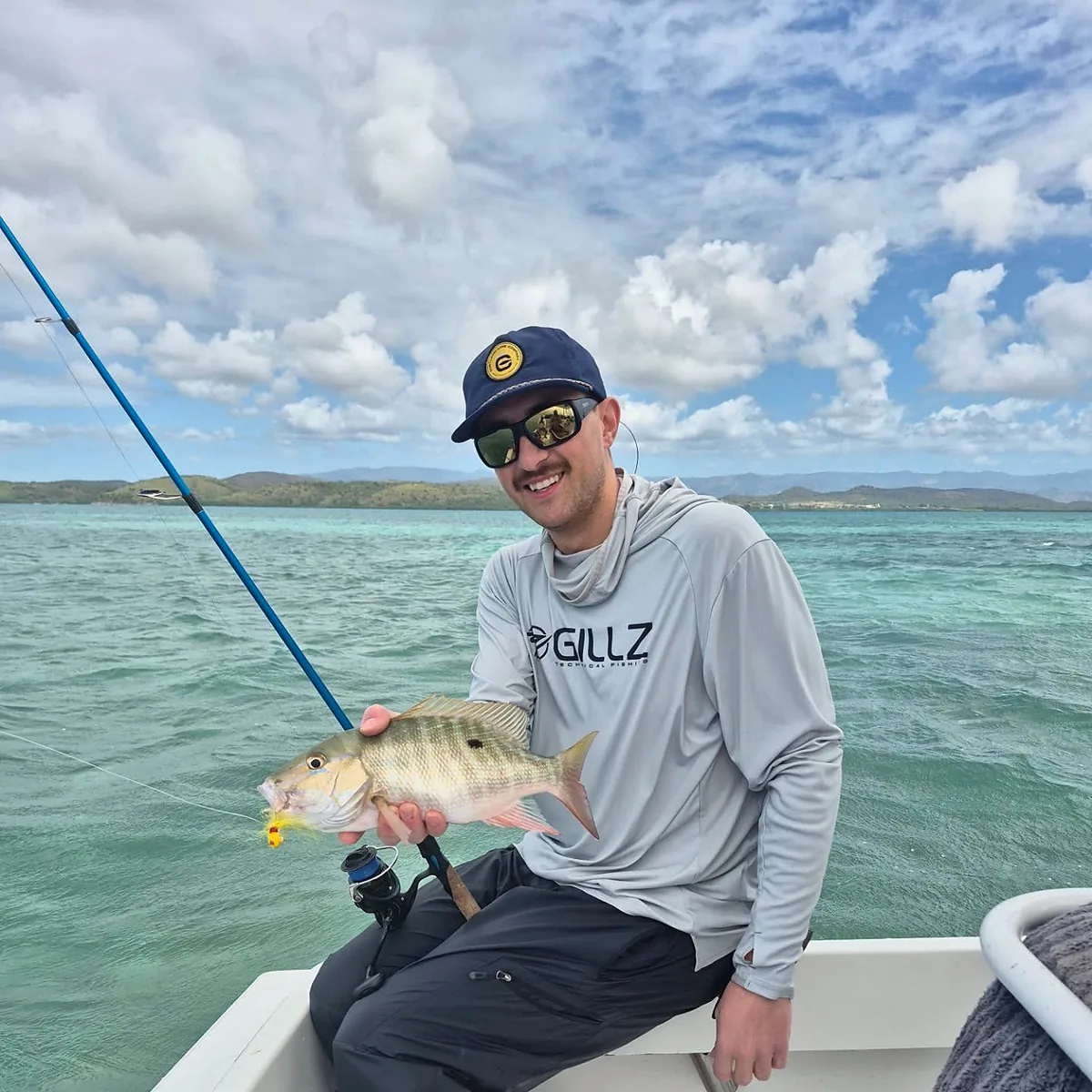 Angler holding a reef fish aboard a Cabo Rojo fishing charter.