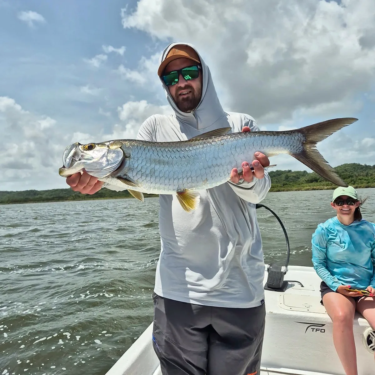 Angler holding a large silver tarpon aboard a Puerto Rico skiff.