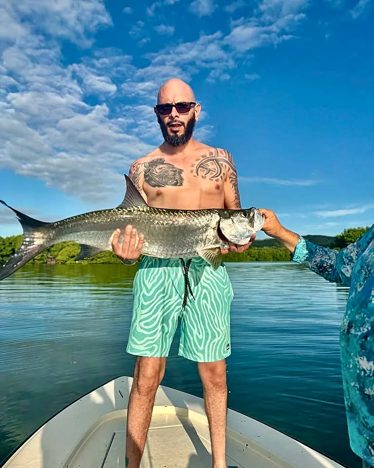 Angler holding a tarpon from a shallow-water skiff near Cabo Rojo.